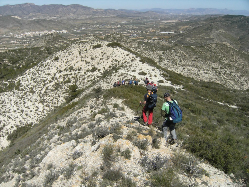 Bajando de la cima del Monte Alto, a la izquierda Hondón de Los Frailes, parte de la Sierra de Los Frailes y detrás la Sierra del Algallet con la Penya de La Mina, al fondo derecha, sierras de l'Arguenya, Cid y Maigmó